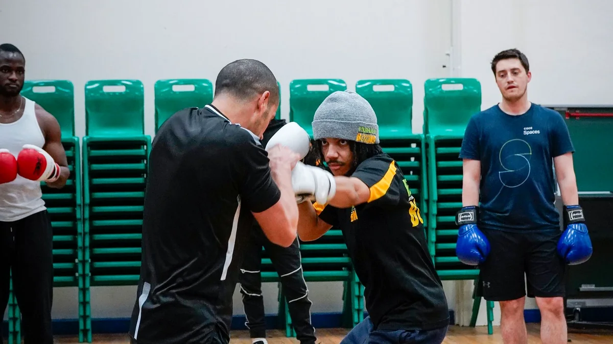 A group of combat-sports athletes training together in a boxing class